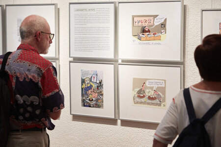 Besucher vor Texten und Karikaturen