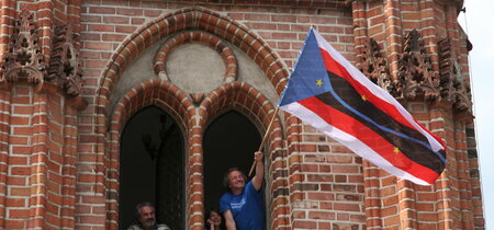 Michael Kurzwelly schwenkt die Fahne Nowa Amerikas aus dem alten Rathaus in Chojna