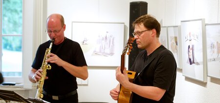 Musikalische Begleitung: Ralf Benschu und Karsten Intrau. Saxophon und Gitarre