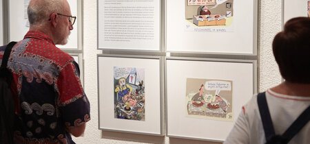 Besucher vor Texten und Karikaturen