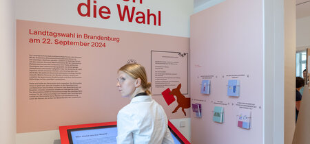 Besucher in der Ausstellung zur Landtagswahl in Brandenburg 2024