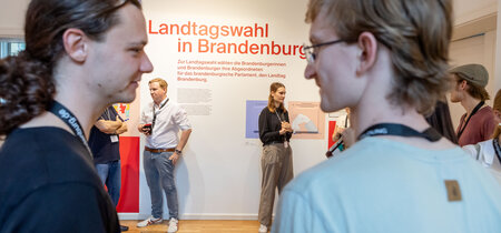 Besucher in der Ausstellung zur Landtagswahl in Brandenburg 2024