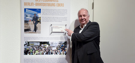 Hans-Peter Goetz mit seiner Leihgabe, der Einladung zur Eröffnung des BER von 2012.