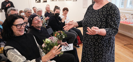 Die Leiterin der Landeszentrale Martina Weyrauch mit Blumen für die Fotokünstler Angelika und Bernd Kohlmeier.