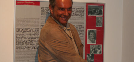 Wolfgang Joop vor der Ausstellungstafel mit Erinnerungen seiner Mutter. Foto: fbn