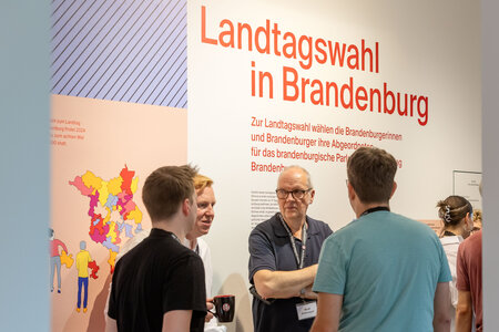 Besucher in der Ausstellung zur Landtagswahl in Brandenburg 2024