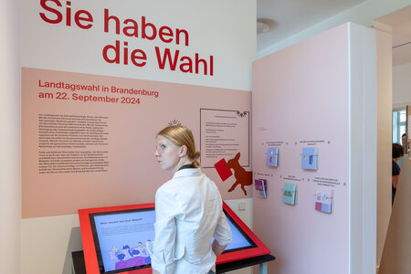 Besucher in der Ausstellung zur Landtagswahl in Brandenburg 2024