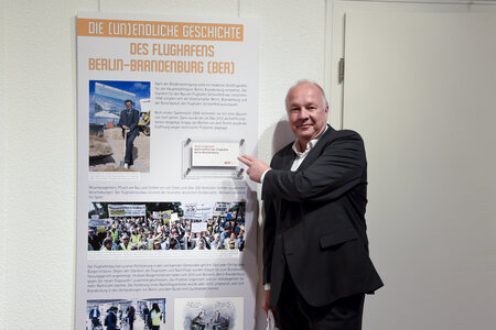 Hans-Peter Goetz mit seiner Leihgabe, der Einladung zur Eröffnung des BER von 2012.