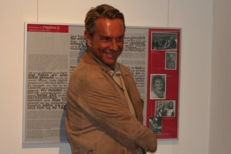 Wolfgang Joop vor der Ausstellungstafel mit Erinnerungen seiner Mutter. Foto: fbn