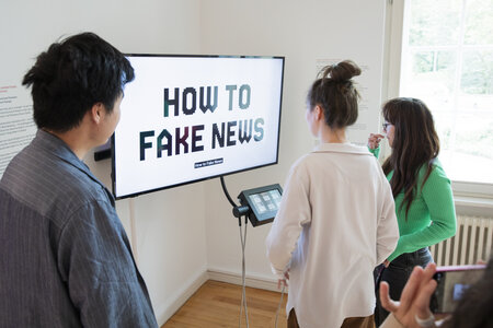 Besucher vor der Medienstation in der Ausstellung zur Landtagswahl 2024