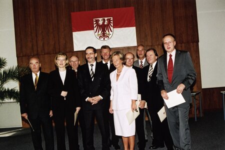 Das Brandenburger Kabinett vor der Brandenburger Landesfahne - die Minister halten ihre Ernennungsurkunden in Händen. 2.v.rechts: Kurt Schelter.