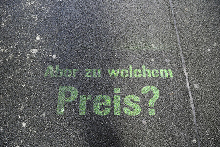 Aufschrift auf der Straße: "Aber zu welchem Preis?"