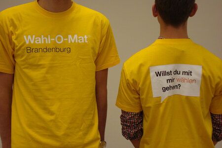 Zwei Personen. Bei tragen ein T-Shirt, das auf den Wahl-O-Mat in Brandenburg hinweist.