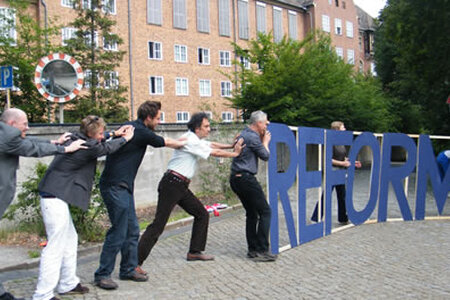 Menschen vor einem Aufsteller "Mehr Demokratie"