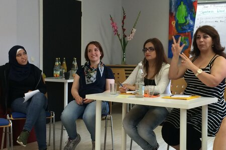 Frauen im Seminar bei HochDrei Frauen verschiedener Herkünfte nehmen an einem Seminar teil und arbeiten zusammen an einem Thema