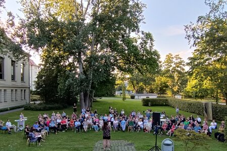 Poetry Slam mit vielen Menschen auf der Wiese der Landeszentrale