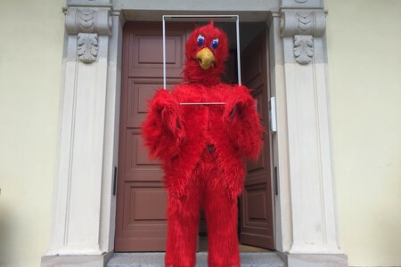 Eine Person im Kostüm des Brandenburger Adler steht vor der Landeszentrale und hält sich einen Bilderrahmen.