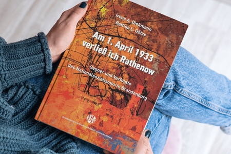 Eine Frau hält das Buch "Am 1. April 1933 verließ ich Rathenow" in der Hand