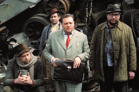 Szene aus dem Spielfilm "Lerchen am Faden", die vier Männer auf einem Schrottplatz zeigt