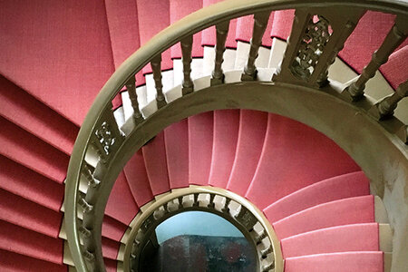 Blick auf die mit rotem Teppich ausgelegte Wendeltreppe im 1753 errichteten Hauptgebäude des ZZF.