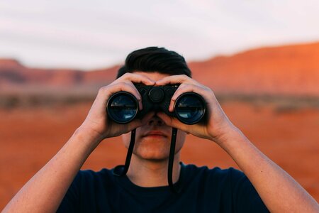 Mann mit Fernglas blickt Richtung Zukunft