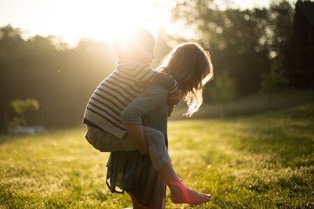 Auf dem Bild sind 2 Kinder zu erkennnen, die in der Natur spielen.
