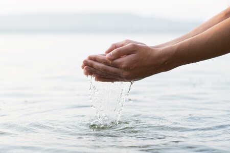 Foto: www.freepik.org Hände schöpfen Wasser aus Naturgewässer
