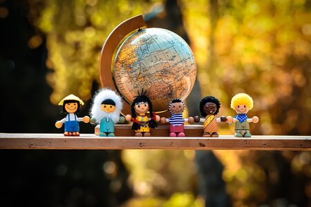 Illustration von Menschen verschiedener Nationalitäten gemeinsam vor dem Globus