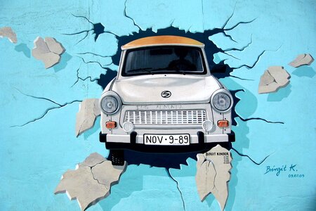 Graffiti Trabi durchbricht Mauer