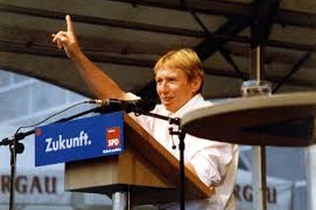 Regine Hildebrandt steht am Rednerpult mit erhobener Hand