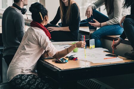 verschiedene Menschen diskutieren an einem Tisch
