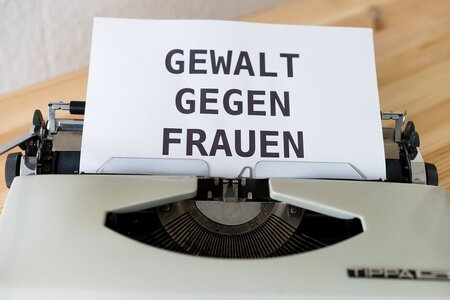 Eine Schreibmaschine mit dem Text "Gewalt gegen Frauen" auf dem Papier