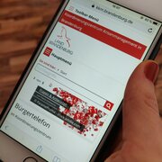 Smartphone, das die Website des Koordinierungszentrums Krisenmanagement in Brandenburg zeigt