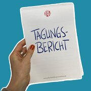 Eine Hand hält einen Block, darauf steht geschrieben "Tagungsbericht". 