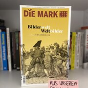 Im Hintergrund ein Bücherregal. Im Vordergrund ein Heft der Zeitschrift die Mark Brandenburg. 