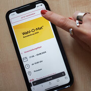 Ein Smartphone liegt auf einem Tisch. Da Display zeigt die Ankündigung für den Wahl-O-Mat-Workshop in Brandenburg. 
