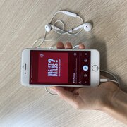 Eine Hand hält ein Smartphone. Das Display des Smartphones zeigt die neue Folge des Podcasts "Was ist da los? Über Politik und Gesellschaft" der Landeszentrale.