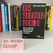 Im Hintergrund eine Reihe Bücher. Im Vordergrund das Buch "Das Schattenregime. Wie der sowjetische Geheimdienst nach 1945 Deutschland terrorisierte" von Christian Neef, daneben ein Schild mit der Aufschrift "Aus unserem Buchshop".