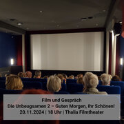 Ein Kinosaal gefüllt mit Menschen, die in Richtung Kinoleinwand schauen. 