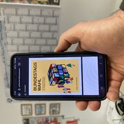 Eine Hand hält ein Smartphone. Das Display zeigt die Informationsbroschüre der Landeszentrale zur Bundestagswahl 2025.