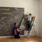 Zwei Personen beim Aufbau der Ausstellung "Napola Potsdam. Erziehung im Nationalsozialismus" in der Landeszentrale.