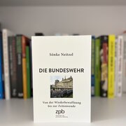 Im Hintergrund eine Reihe Bücher. Im Vordergrund das Buch „Die Bundeswehr. Von der Wiederbewaffnung bis zur Zeitenwende“ von Sönke Neitzel.