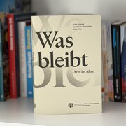 Das Buch "Was bleibt - Arm im Alter" steht in einem Bücherregal. 