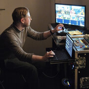 Eine Person sitzt an einem Technikpult.