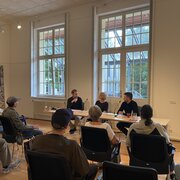  Sebastian Stude, Referent in der Landeszentrale, sitzt gemeinsam mit Grit und Niklas Poppe auf einem Podium. 