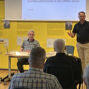  Sebastian Stude, Referent für Ausstellungen/Öffentlichkeitsarbeit in der Landeszentrale, begrüßt die Besucherinnen und Besucher der Veranstaltung „Die Treuhandanstalt und die ostdeutsche Chemie- und Mineralölindustrie“, neben ihm sitzt Rainer Karlsch.