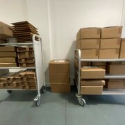 Zwei Wagen mit Paketen stehen in einem Flur.