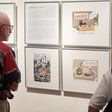 Besucher vor Texten und Karikaturen