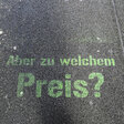 Aufschrift auf der Straße: "Aber zu welchem Preis?"