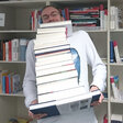 Kai Schreiweis mit einem Stapel Bücher